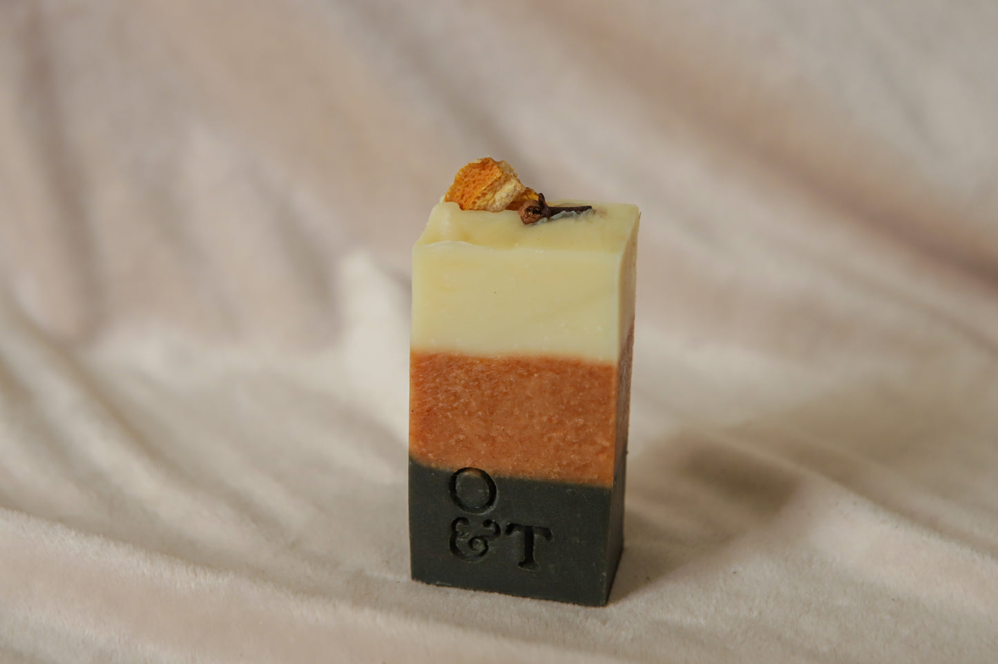 Spice half soap bar, creamy orange and black stripes topped with orange slice and cloves
