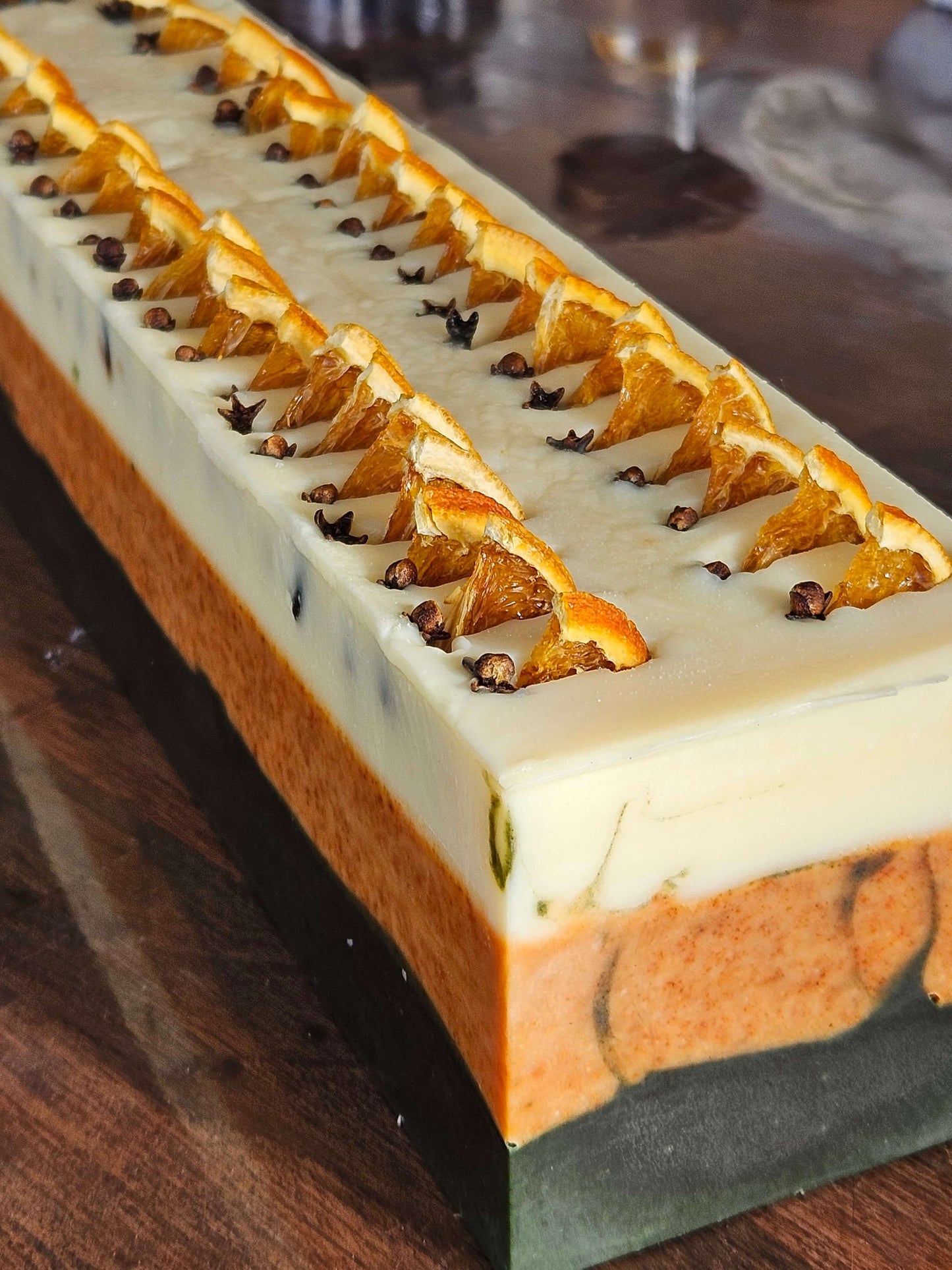 Spice soap loaf, black, orange and creamy white, ready to be cut into individual soaps